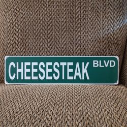 CHEESESTEAK BLVD. METAL SIGN.  16" X 4".  NEW.  PICKUP ONLY.