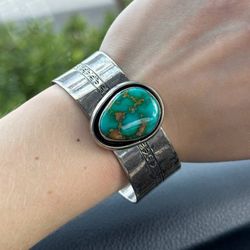 This gorgeous bracelet made of 925 sterling silver with approximately 10   Carat total weight of pear shape natural turquoise stone in the middle. Thi