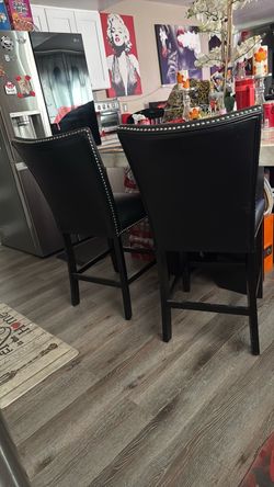Four black leathered, like studded chairs Four black leather, like studded chairs