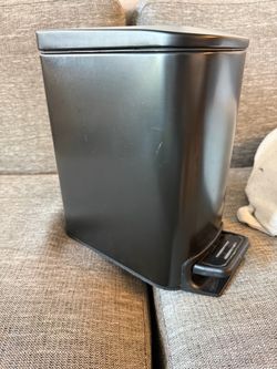 Small black metal trash can
