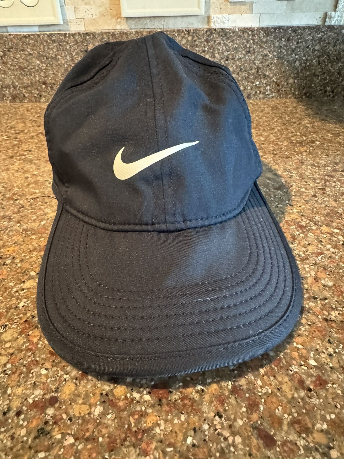 Nike Kids Black Featherlight Dri-fit hat. Adjustable back strap. Fits Little Kids/Youth. See Below