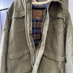 Warm OUTDOOR LIFE parka jacket. Olive green color with a cozy sherpa lined hood. Plaid lining inside. Has lots of pockets and a zipper with snap closu