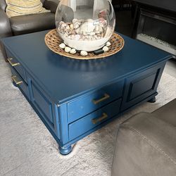 Square blue coffee table with drawers . It’s very solid .