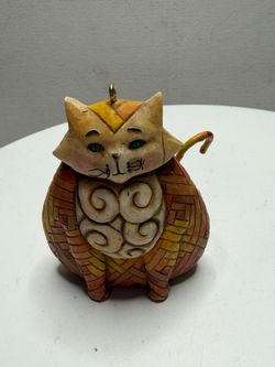 Model and Artist: The figurine is named "Elijah" and was created by artist Jim Shore for the company Enesco. Design: The cat features a distinctive pa