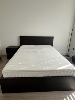 Queen bed frame, mattress, and side table for sale.
