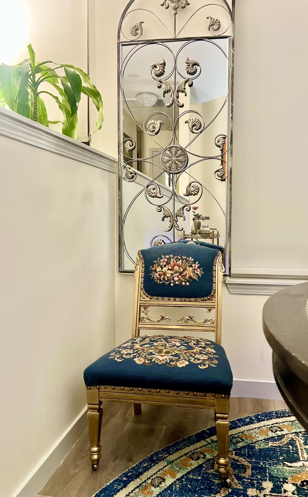 Antique embroidered accent chair on coasters .