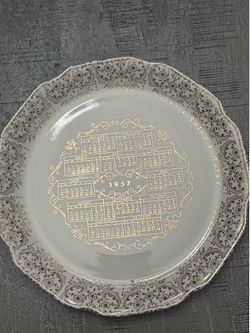 1957 porcelain calendar collector plate featuring a scalloped rim and metallic gold floral filigree scrollwork.