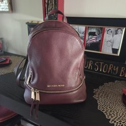 Michael kor's maroon backpack.