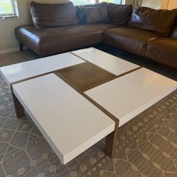 a modern engineered wood square coffee table with a white and brown finish.