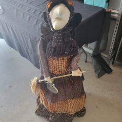 Tall witch decoration with broom and hat, perfect for Halloween.