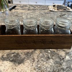 Rustic wooden caddy with four clamp-lid glass jars