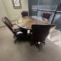 Four Leather Chairs And Round Wooden Table