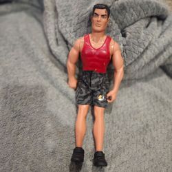 vintage 1997 Hasbro Action Man figure wearing a red tank top and camouflage shorts.