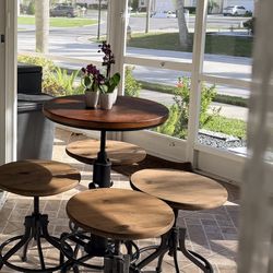 The furniture set in the image is an industrial-style adjustable bar table and stools set. This type of furniture features a combination of a wood sea