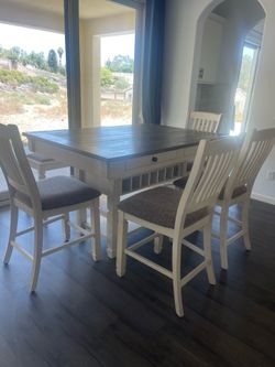 Brand new Ashley furniture dining table with four chairs.