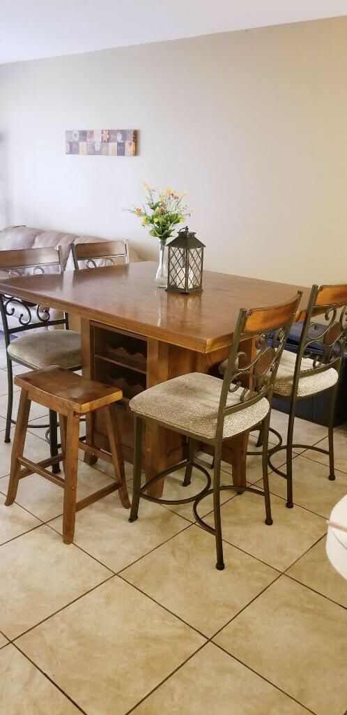 Brown dining table with built in wine rack and chairs