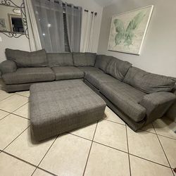 Living spaces .  Sectional couches gray color with big ottoman