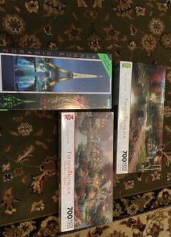 THOMAS KINCAID 700 PIECE PUZZLES, AND A 3 D EIFFEL TOWER PUZZLE