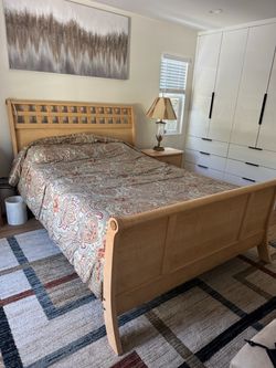 Queen Sleigh Bed Frame Light Wood and mattress and one nightstand