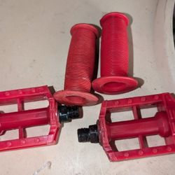 2 Tricycle Handle Bar Grips and 2 Pedals With Reflectors On Them.