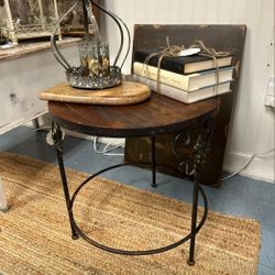 Round side table with a rustic wooden top, black iron base