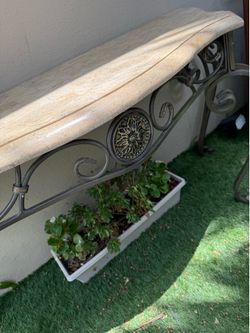 Mesa de recibidor estilo clásico. Cubierta tipo mármol y patas de hierro.