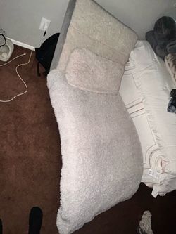 White faux fur lounger with blanket and pillow