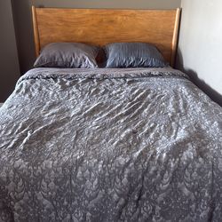 Living spaces queen sized bed with bed frame and two pillows