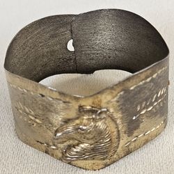 Vintage metal cuff bracelet featuring a stamped or embossed design of a zebra