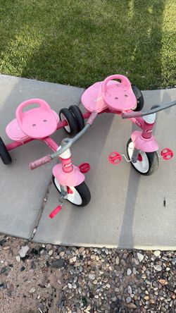 2 pink radio flyer tricycles