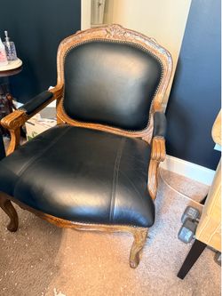 2 black leather chairs with antique wooden arms