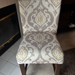 BRAND NEW UPHOLSTERED BAR STOOL WITH SOLID WOOD LEGS. BEIGE/TAUPE. SHARP!