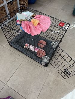Medium dog crate with bowls, crate mat, and other stuff