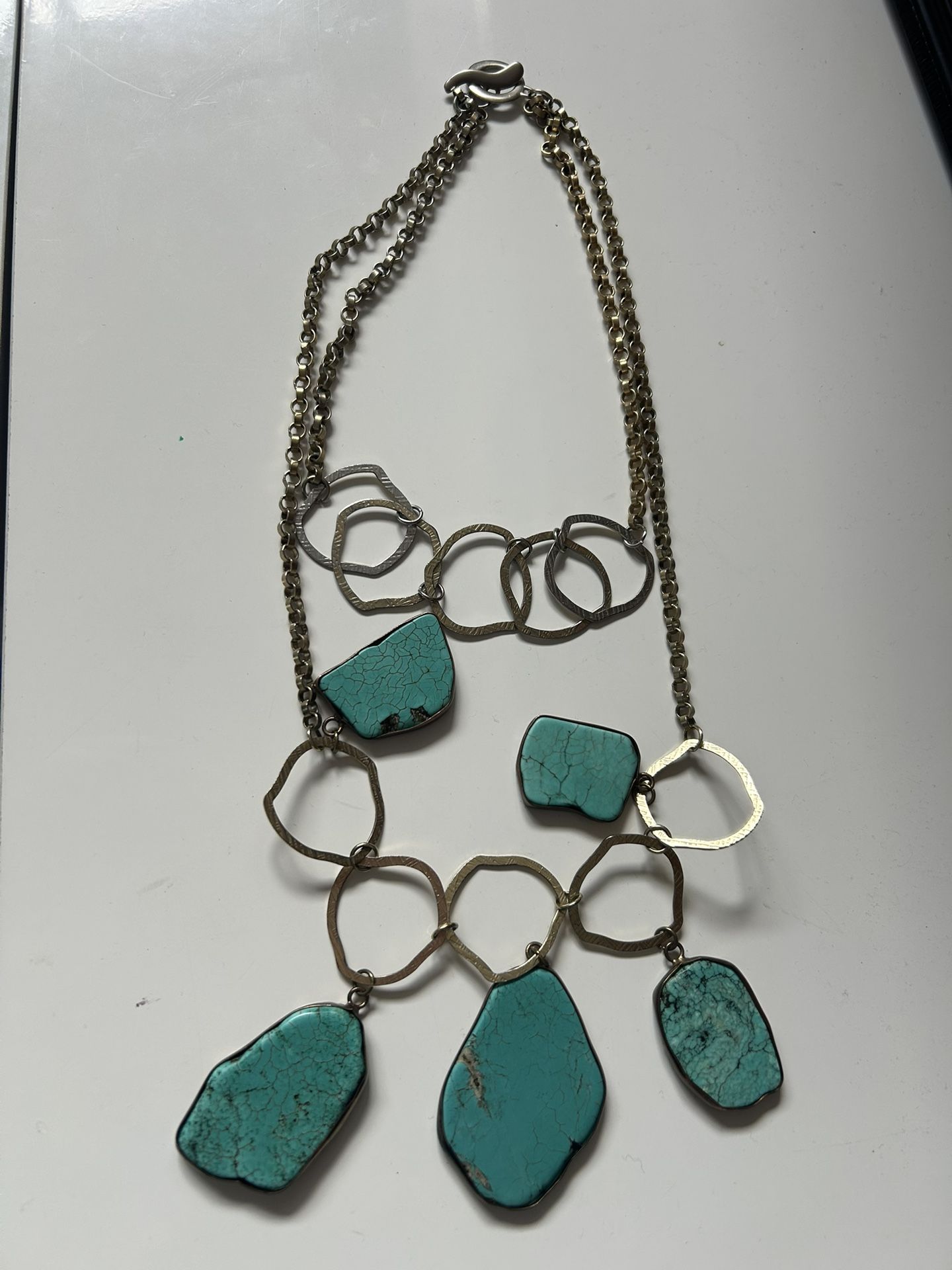 multi-strand necklace with turquoise stones and brass-toned links.