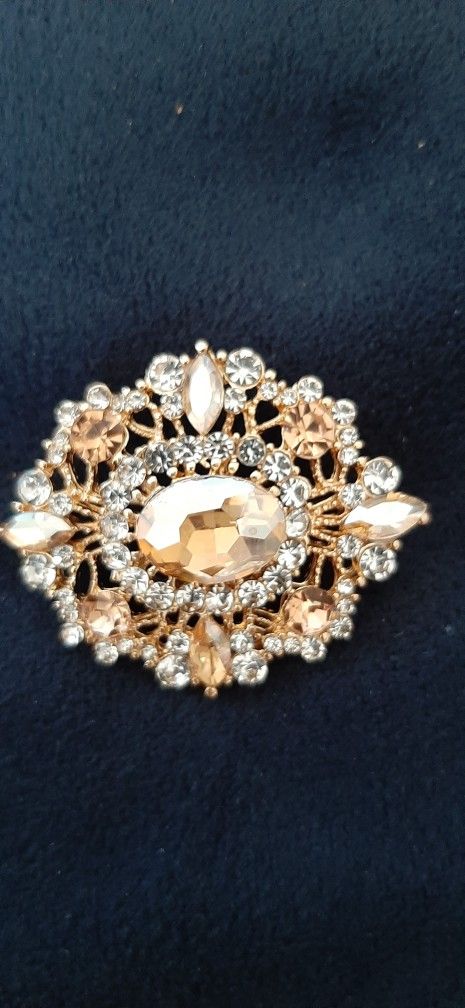 Elegant vintage look brooch adorned with crystals.