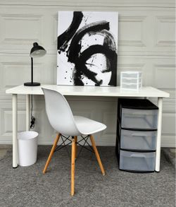 Desk, chair, lamp and plastic storage drawers.