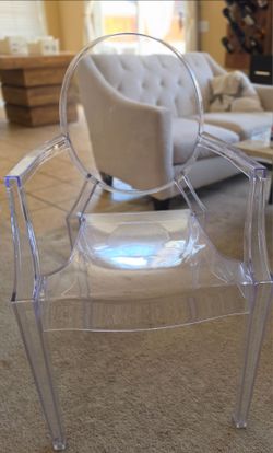 Transparent armchair is made of clear acrylic material. It has a rounded backrest and integrated armrests in a classic Louis Ghost design.
