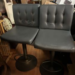 Pair of height-adjustable grey faux leather swivel bar stools
