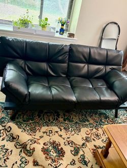 Like New. Black comfortable Futon sofa bed drop down- black faux leather