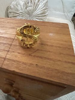 Money sign ring, color gold, size 9 through 10.