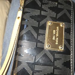 Black Wallet With Tan Wrist Strap. Zippered With Gold Accent Trim.