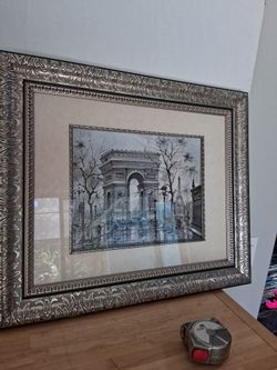This framed print appears to be a 1975 Maurice Legendre "L'Arc de Triomphe" piece with a heavily ornate silver frame.
