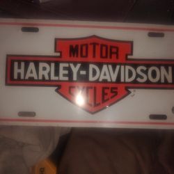 It is a vintage-style license plate featuring the classic Harley-Davidson logo.