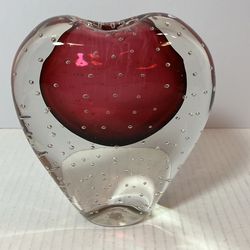 This item is a Murano-style art glass vase featuring a heart shape with red glass encased in clear glass with a controlled bubble (bullicante) techniq