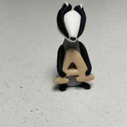 Black and White Skunk Holding “a”