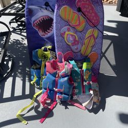 Two boogie boards and three kids lift vest