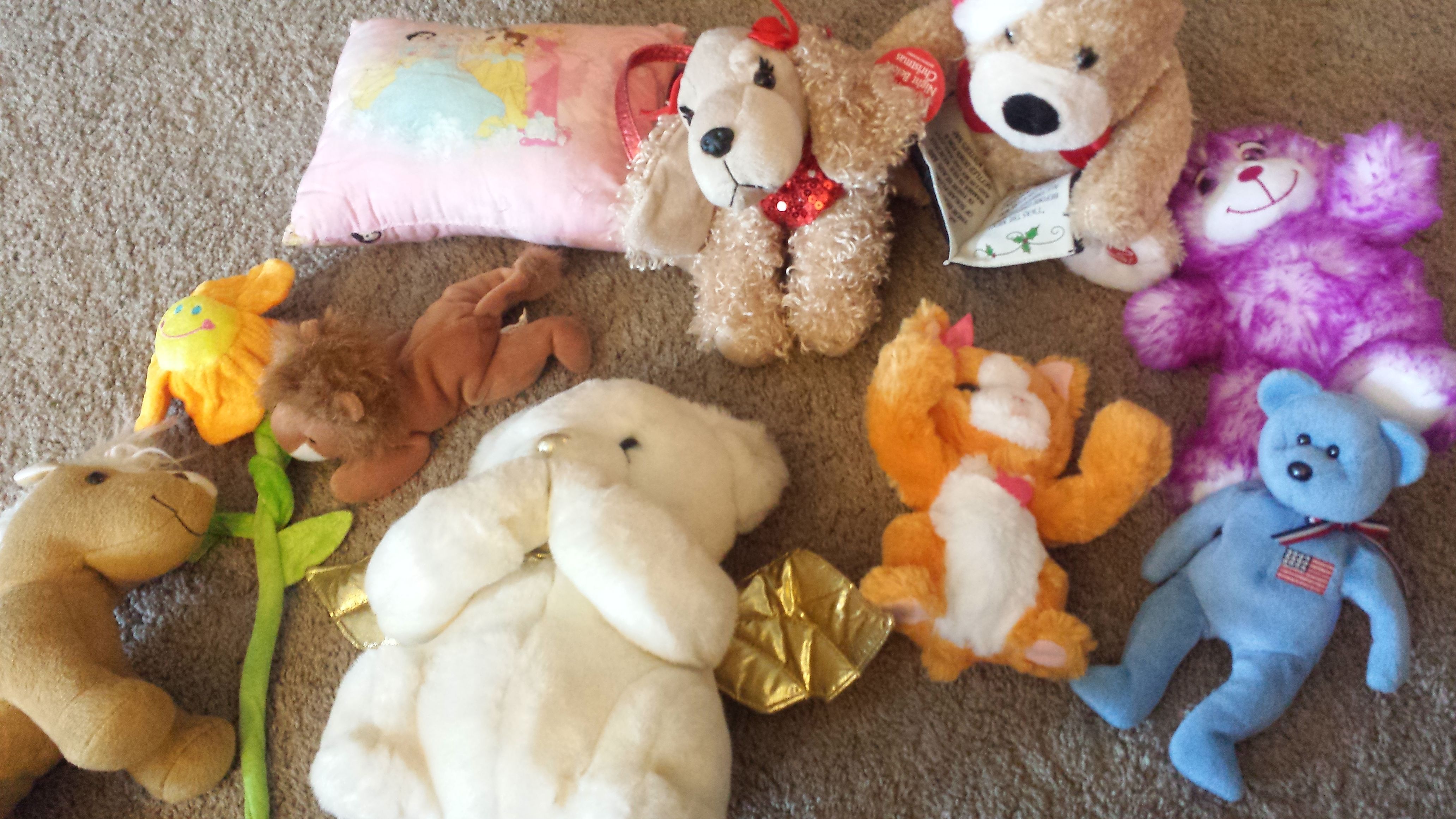 Lot of stuffed animals and one purse shaped puppy
