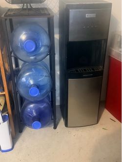 Igloo water dispenser w four 5 gallon water jugs and rack