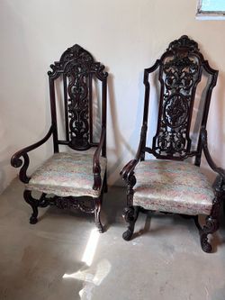 Pair of walnut throne chairs with detailed carving