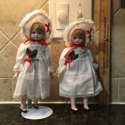 Two Porcelain Holiday Dolls and One Doll Stand